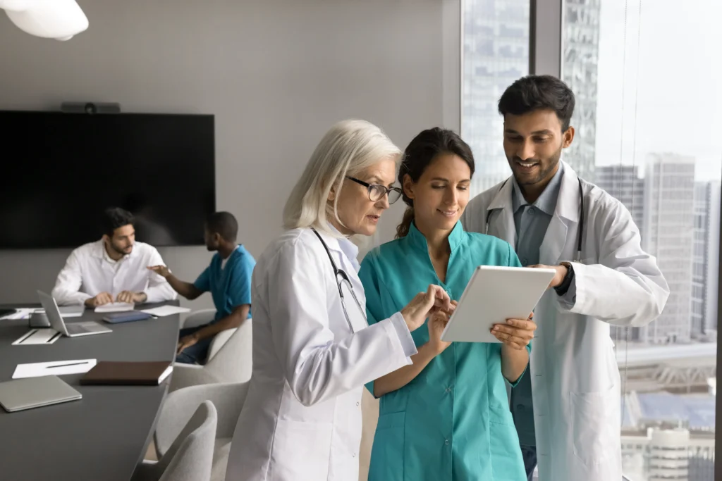 Healthcare professionals looking at their cardiology pacs system interface on a tablet.